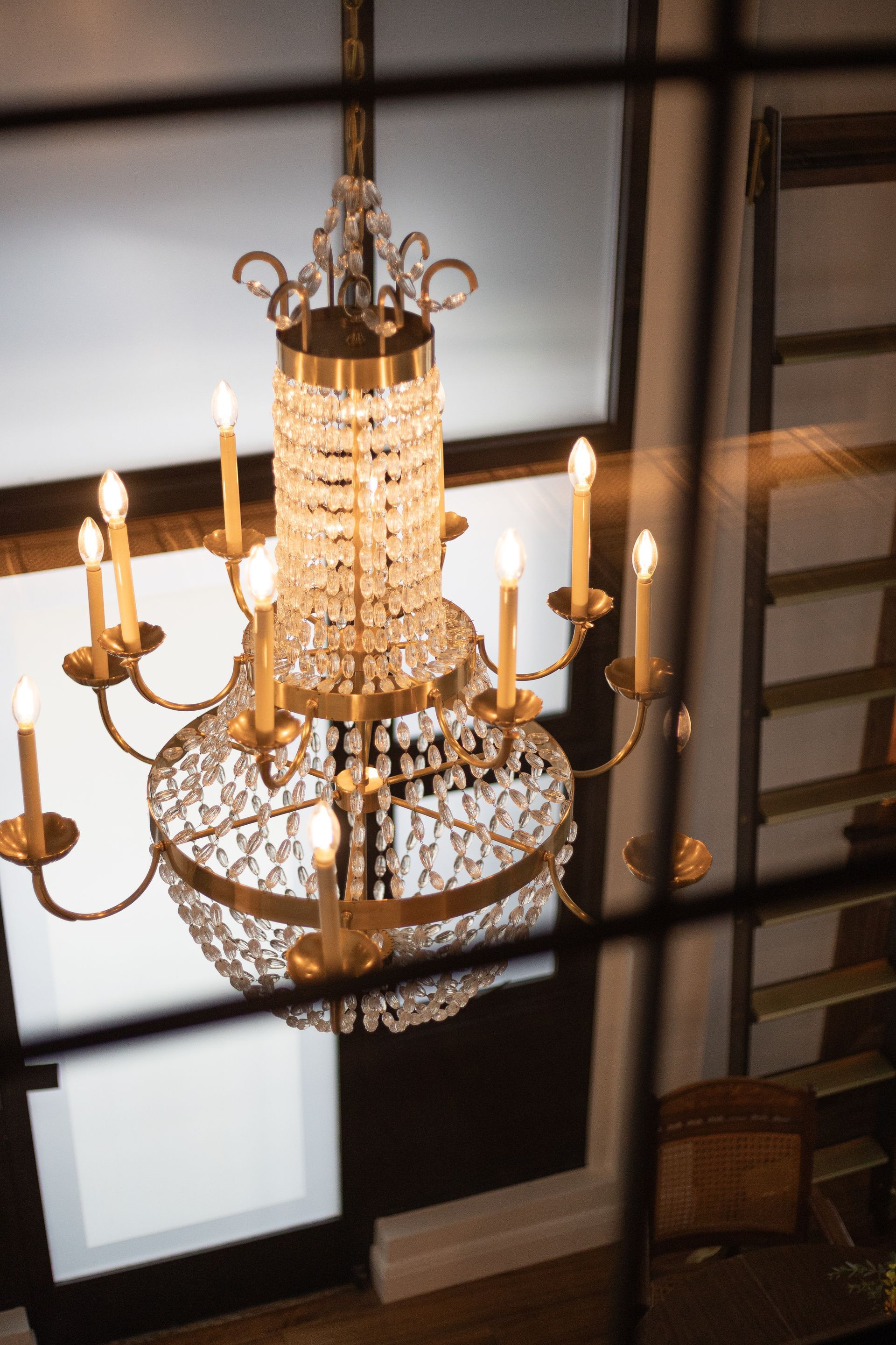 Crystal chandelier hanging in a room, viewed from above, seen through a window.