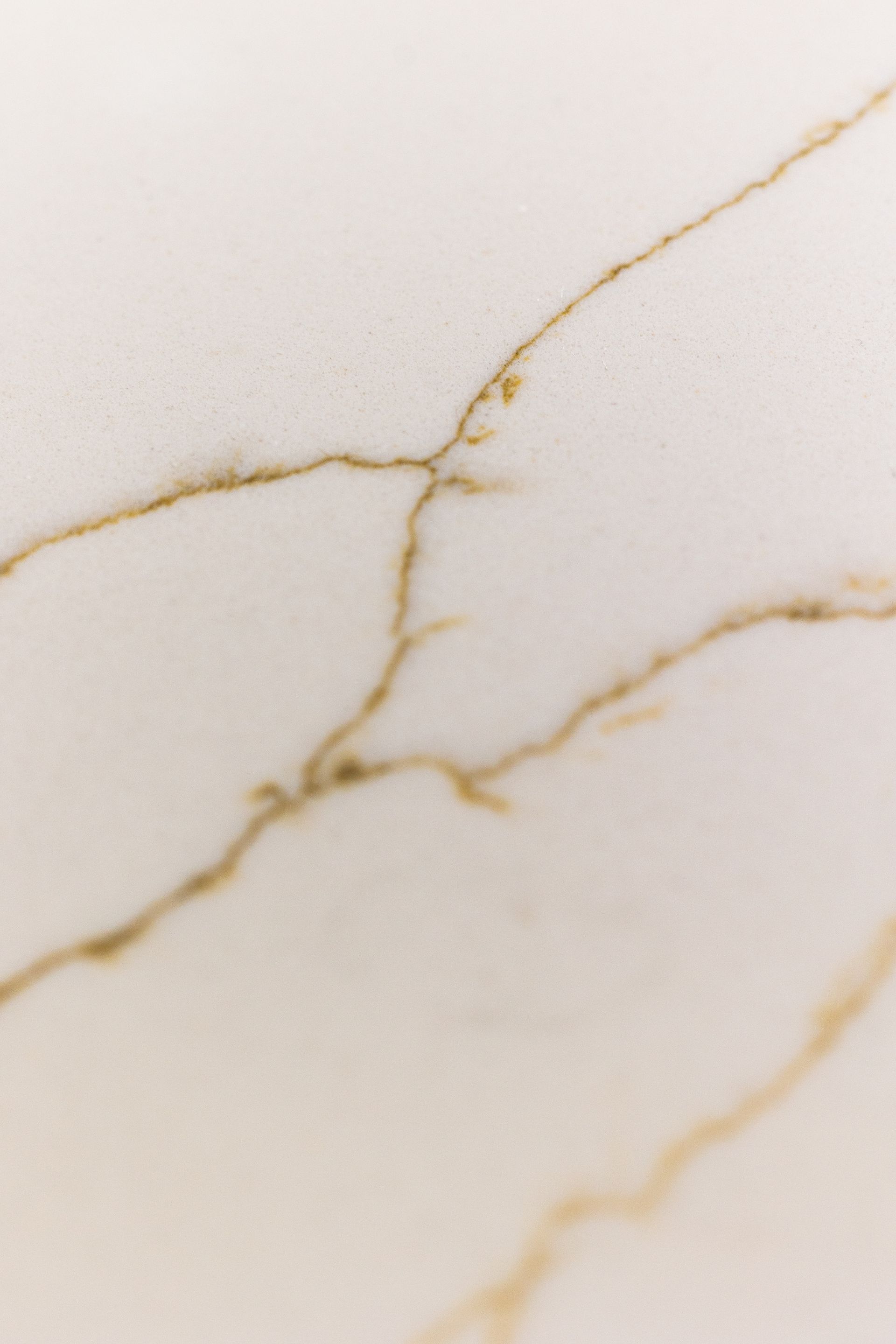 White surface with golden veining.