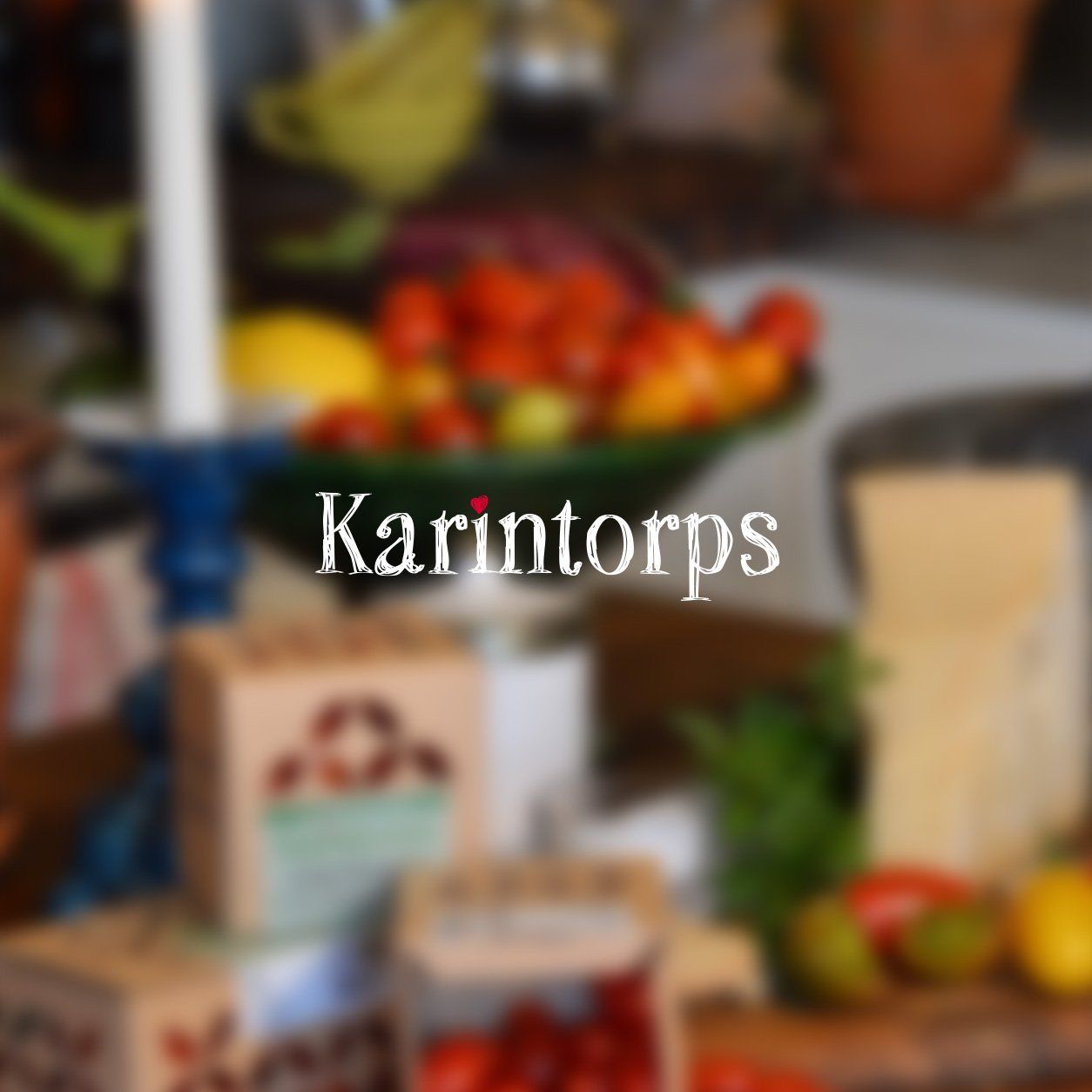 Karintorps tomaters logotyp mot en bild av tomater och andra delikatesser
