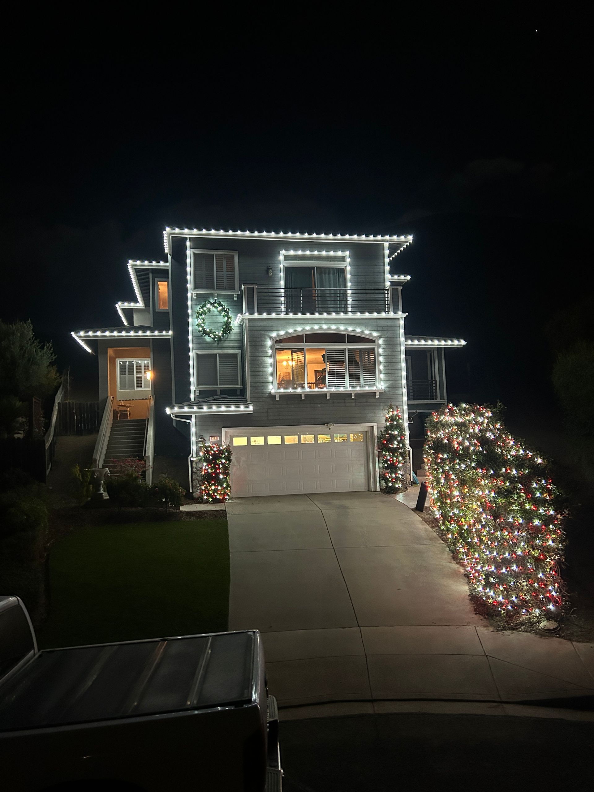 A large house is decorated with christmas lights at night.