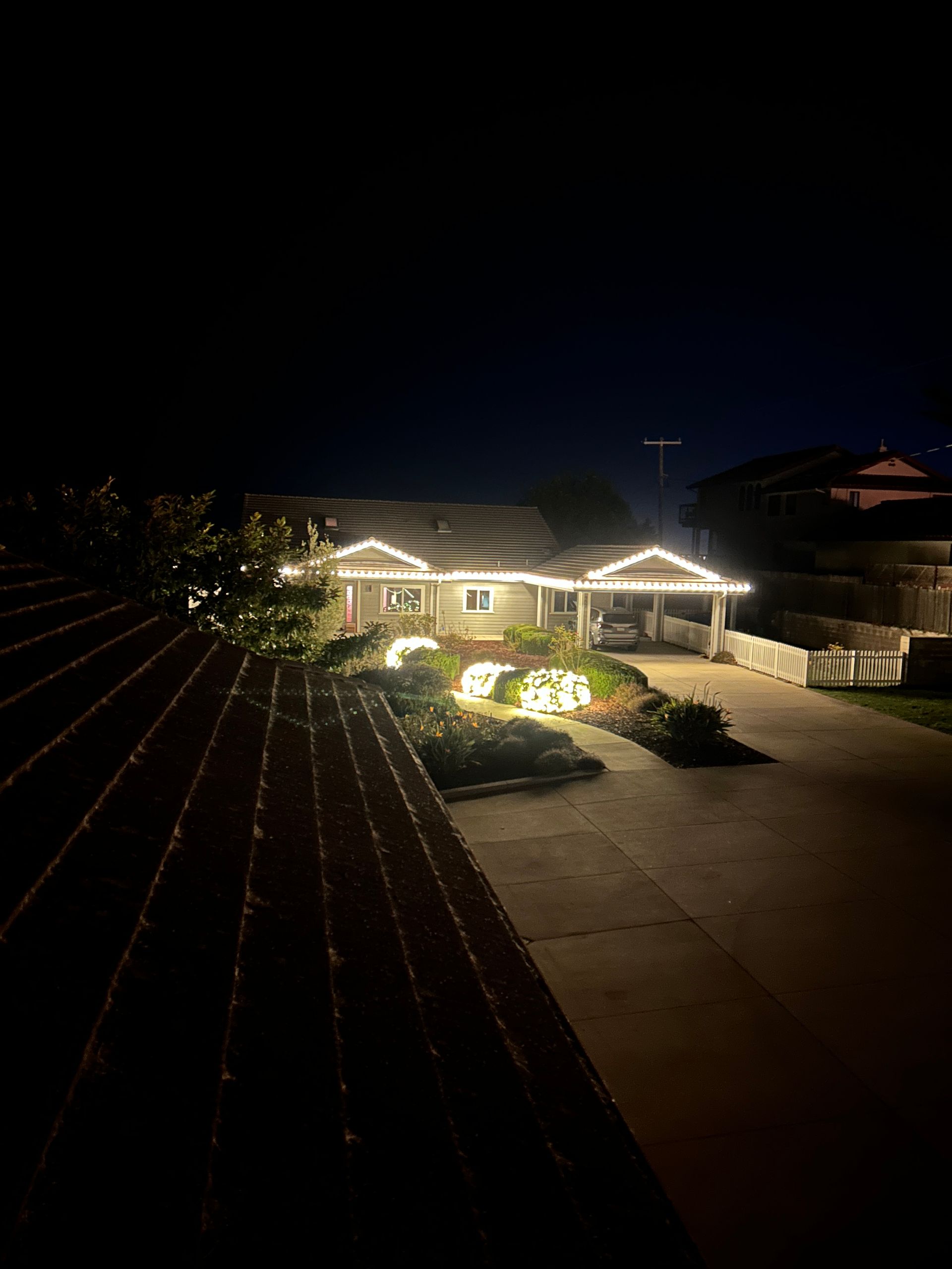 A house is lit up at night with christmas lights.