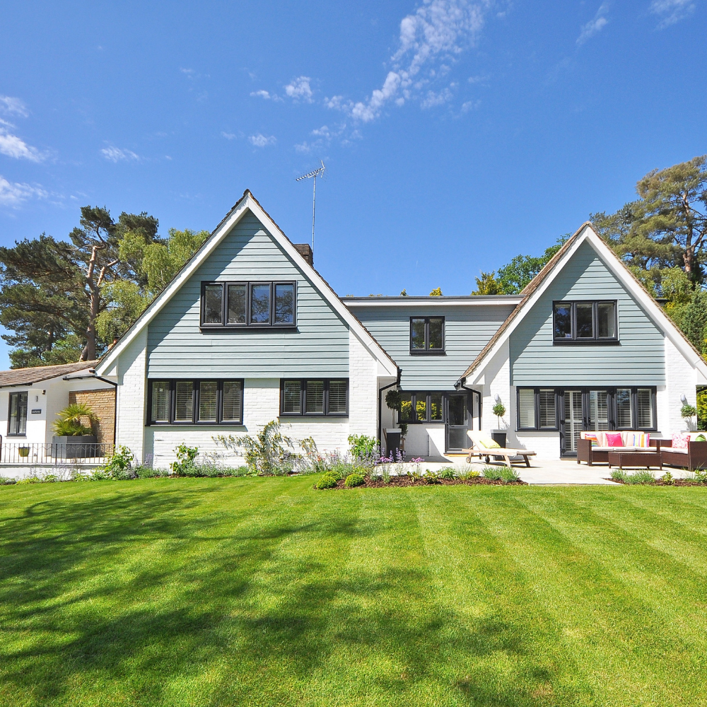 A large house with a lush green lawn in front of it.