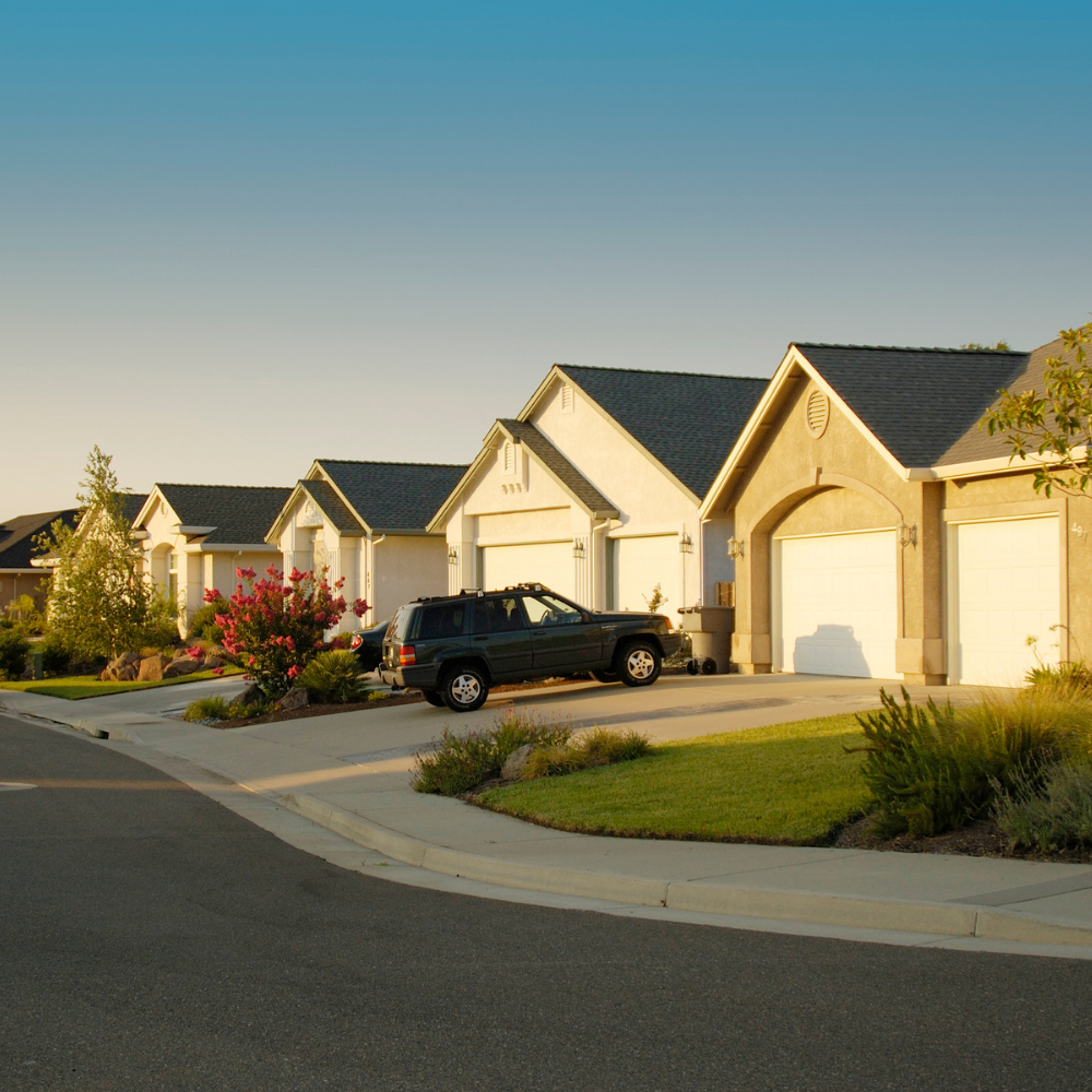 A black suv is parked in front of a row of houses