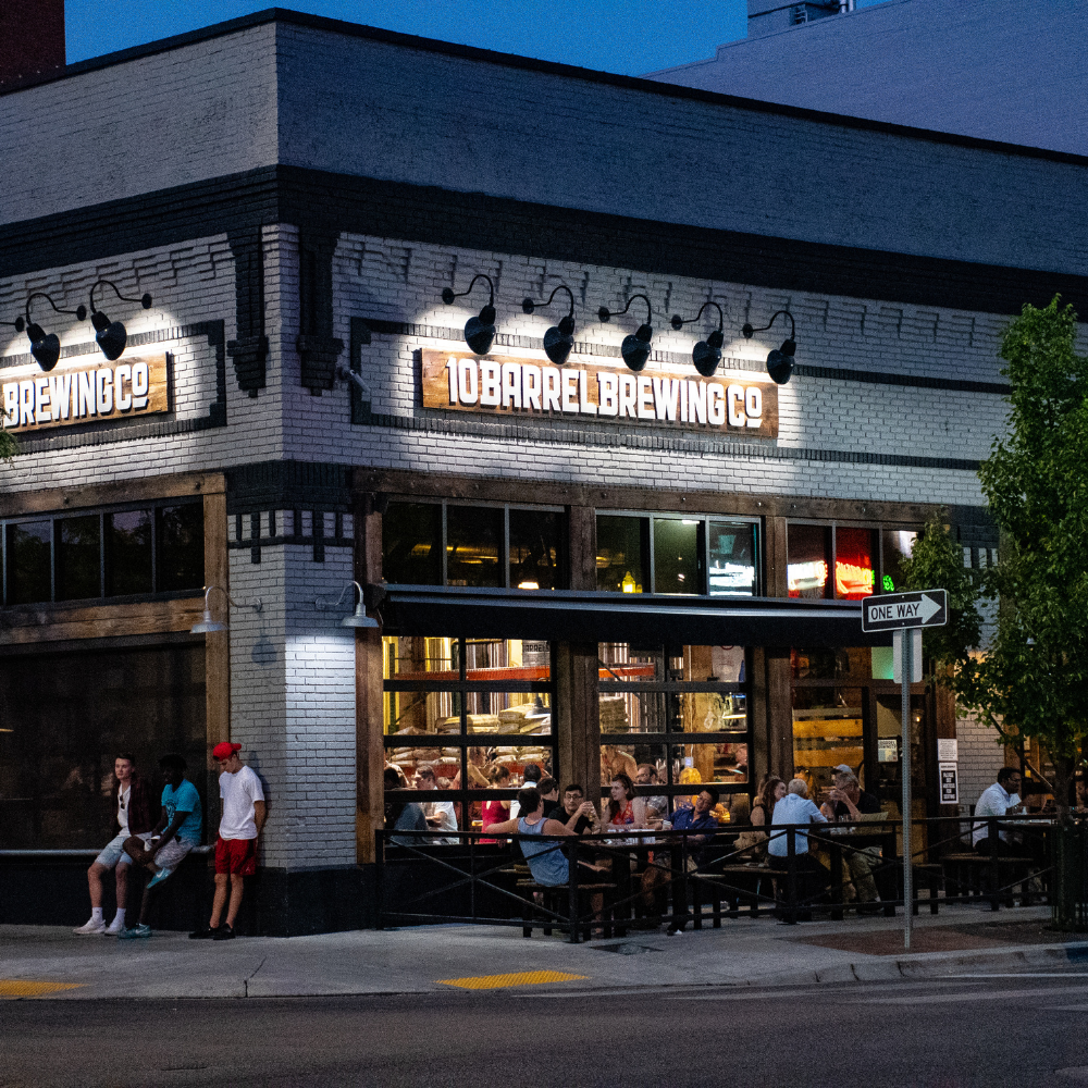A restaurant called 10 barrel brewing co has people sitting outside