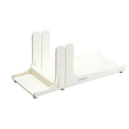 Auf einem weißen Tisch steht eine weiße Brotschneidemaschine.