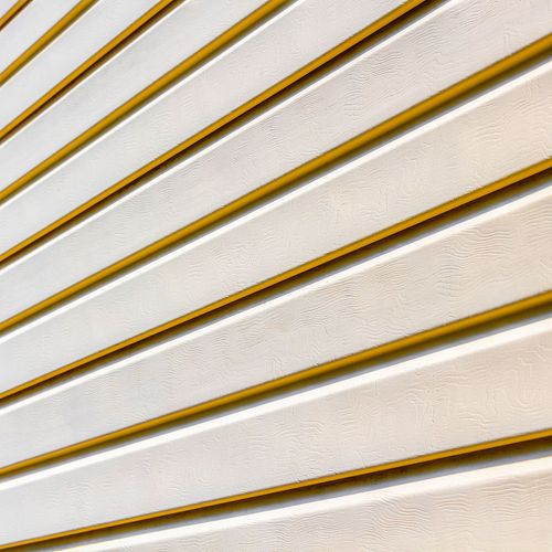 A close up of a white siding with a yellow trim.