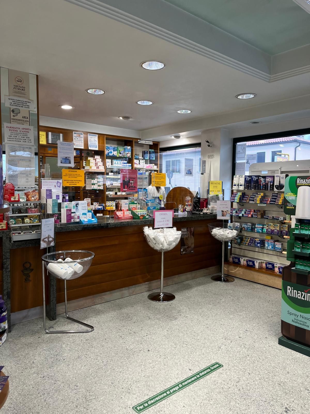 L'interno di una farmacia con bancone e scaffali.