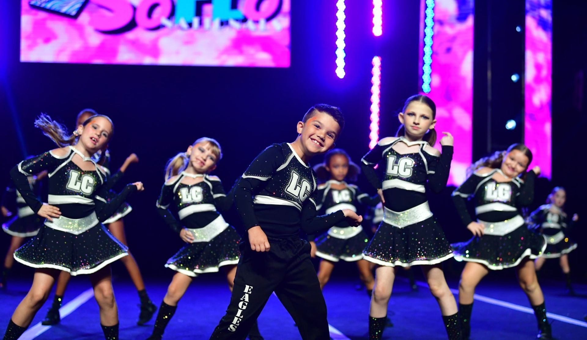 A group of young dancers are performing on a stage.