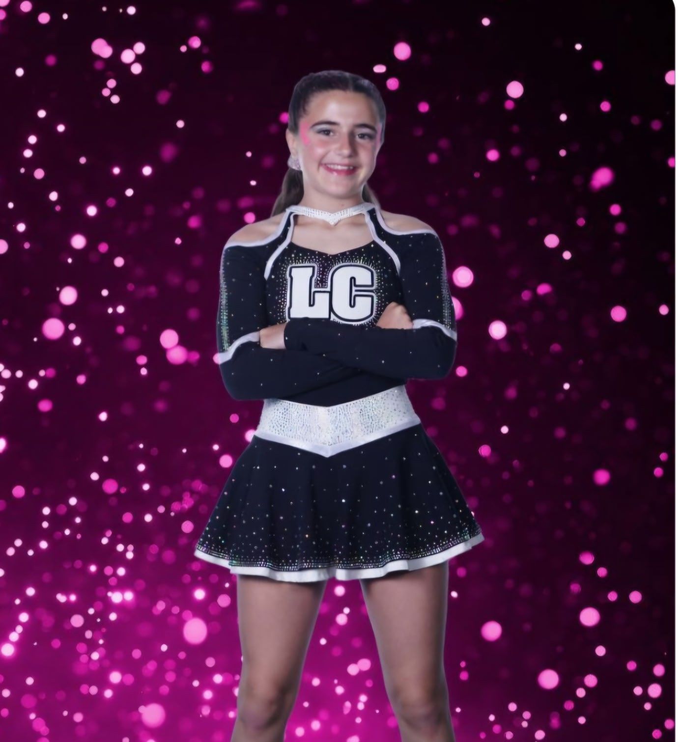 A girl in a cheerleading uniform with the letter lc on it