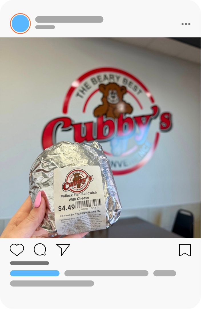 Wrapped burger held up in front of a Cubby’s restaurant sign.