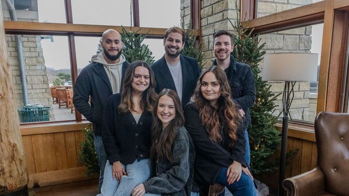 A group of people are posing for a picture in a seating room.