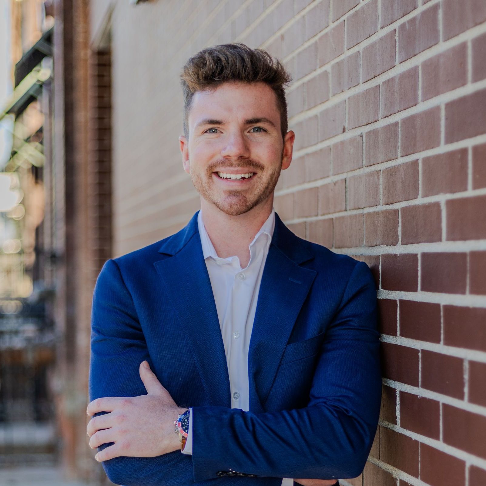 A man in a suit and tie is smiling for the camera