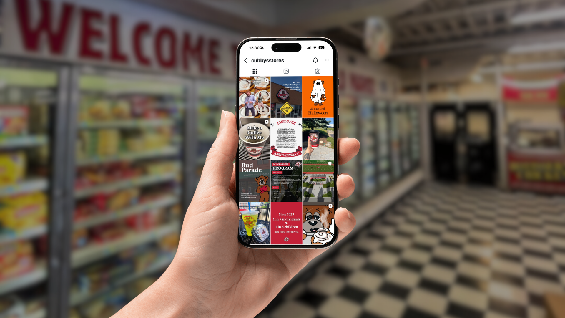 A hand holds a smartphone displaying an Instagram grid profile, with a blurred grocery store aisle in the background.