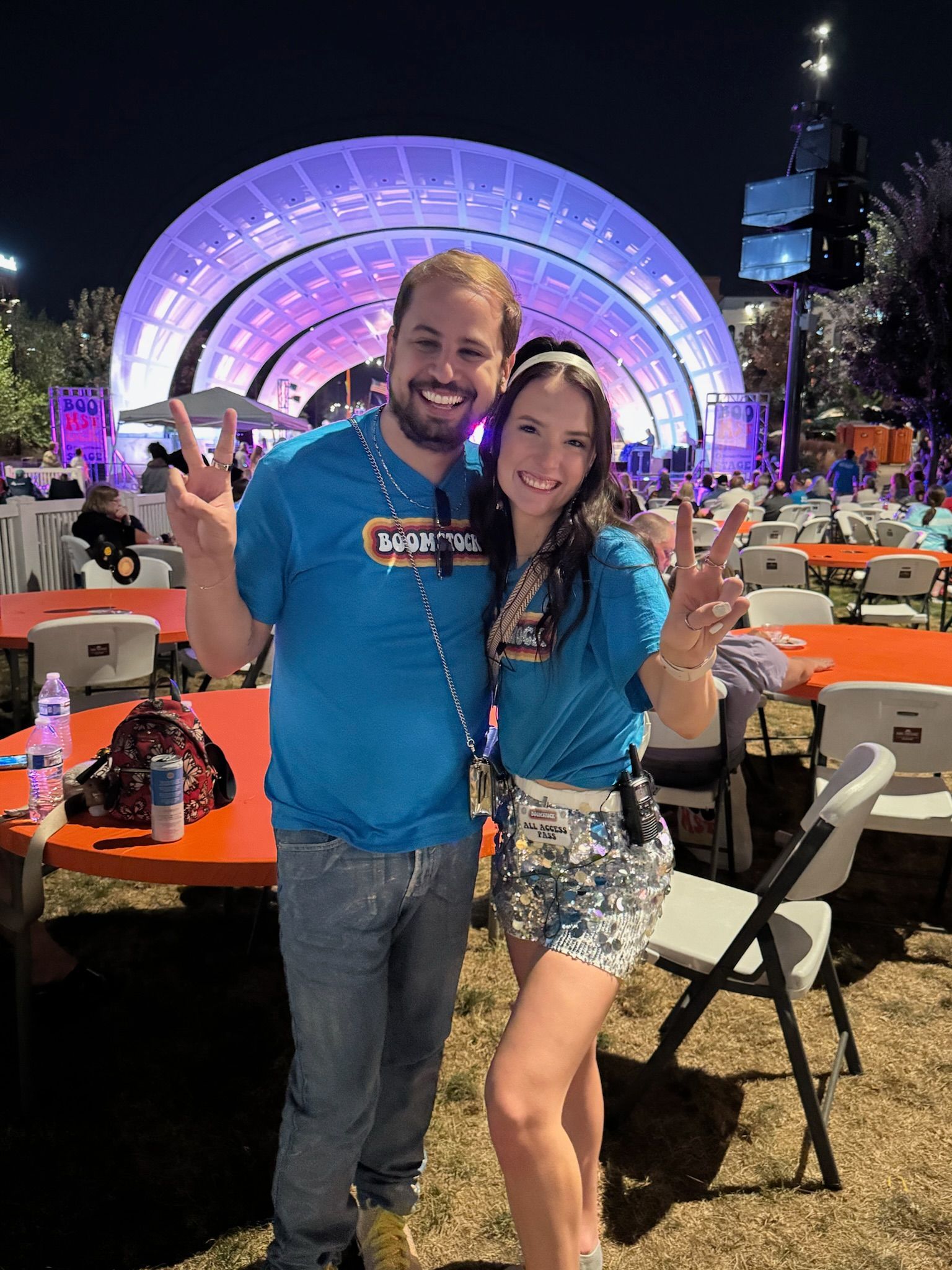A man and a woman are posing for a picture at a concert.
