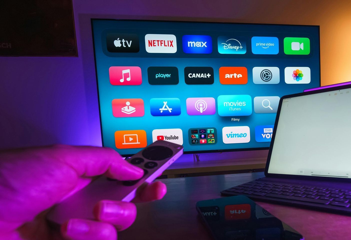 A person is holding a remote control in front of a tv.