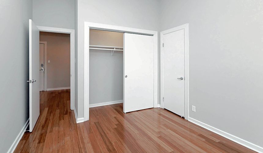 An empty bedroom with hardwood floors and a closet at Reside on Clark.