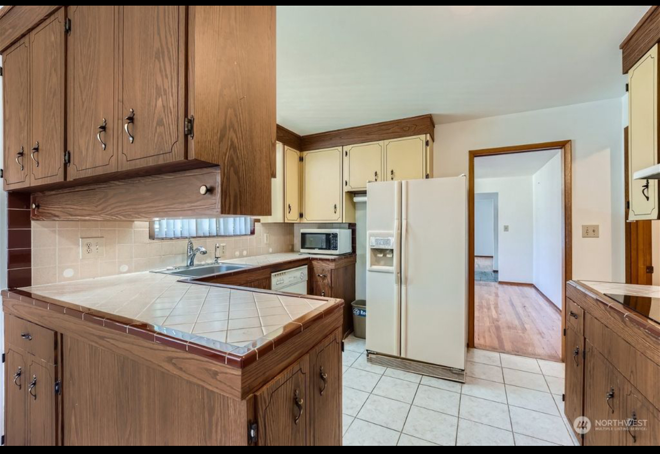A kitchen with wooden cabinets and a white refrigerator