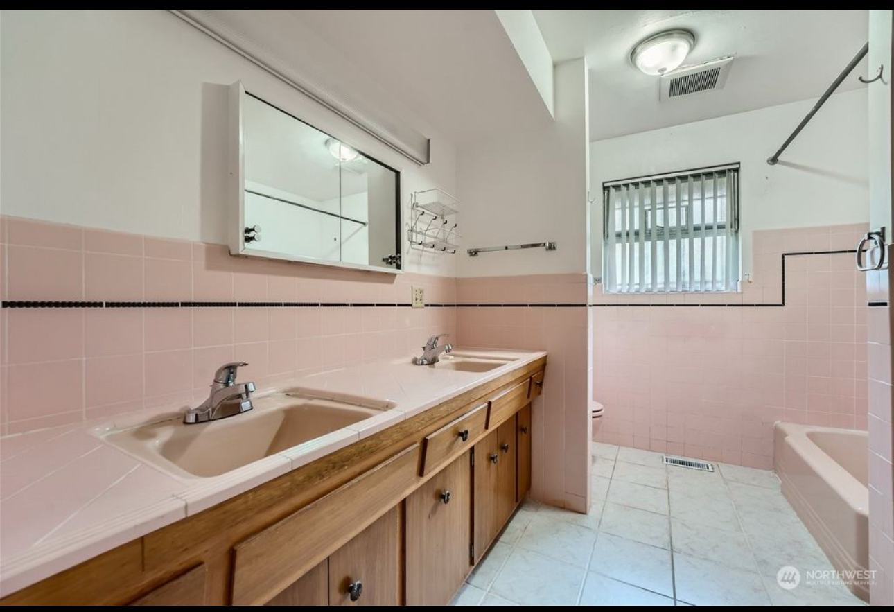 A bathroom with pink tiles and two sinks