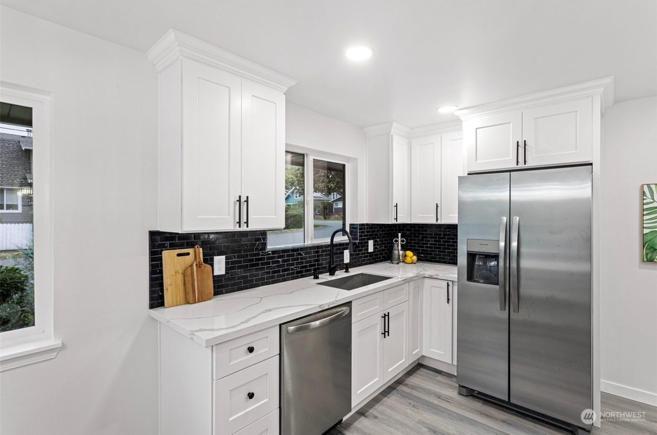 A kitchen with white cabinets and stainless steel appliances.