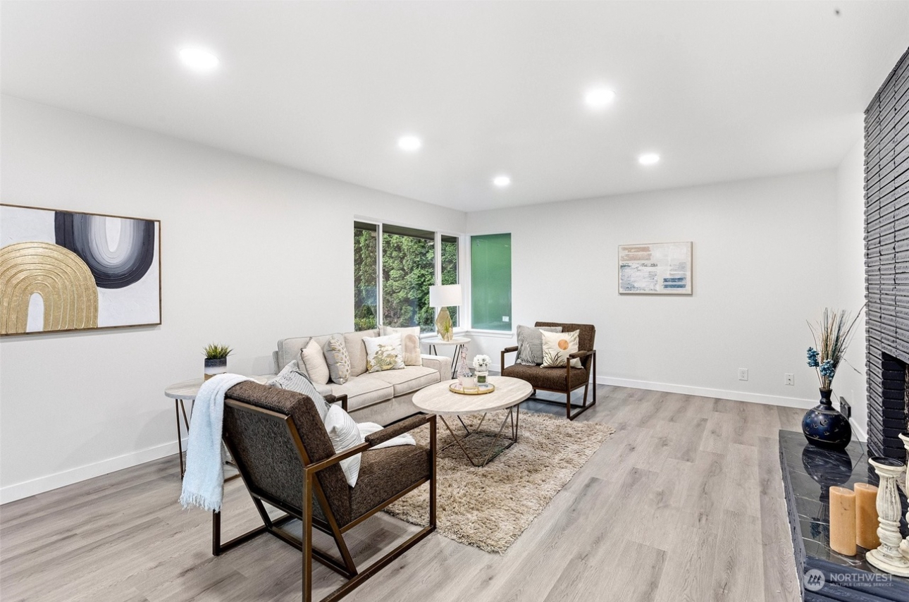 A living room with a couch , chairs , coffee table and fireplace.