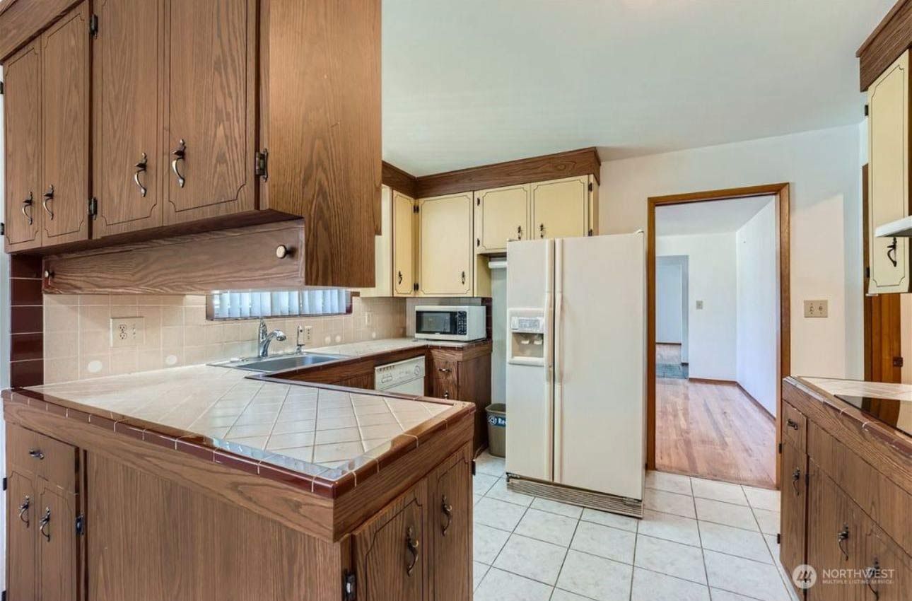 A kitchen with wooden cabinets and a white refrigerator