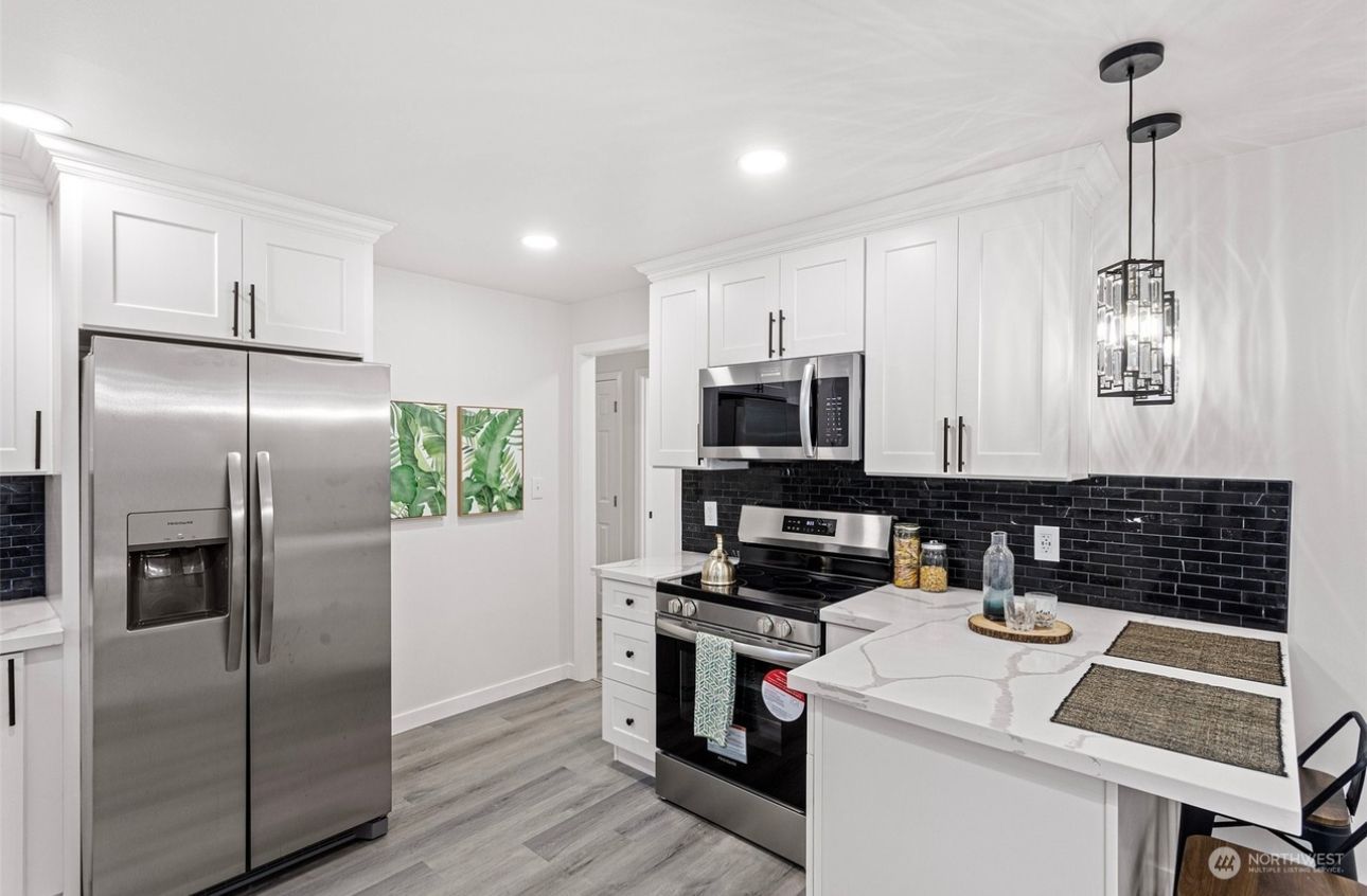 A kitchen with stainless steel appliances and white cabinets