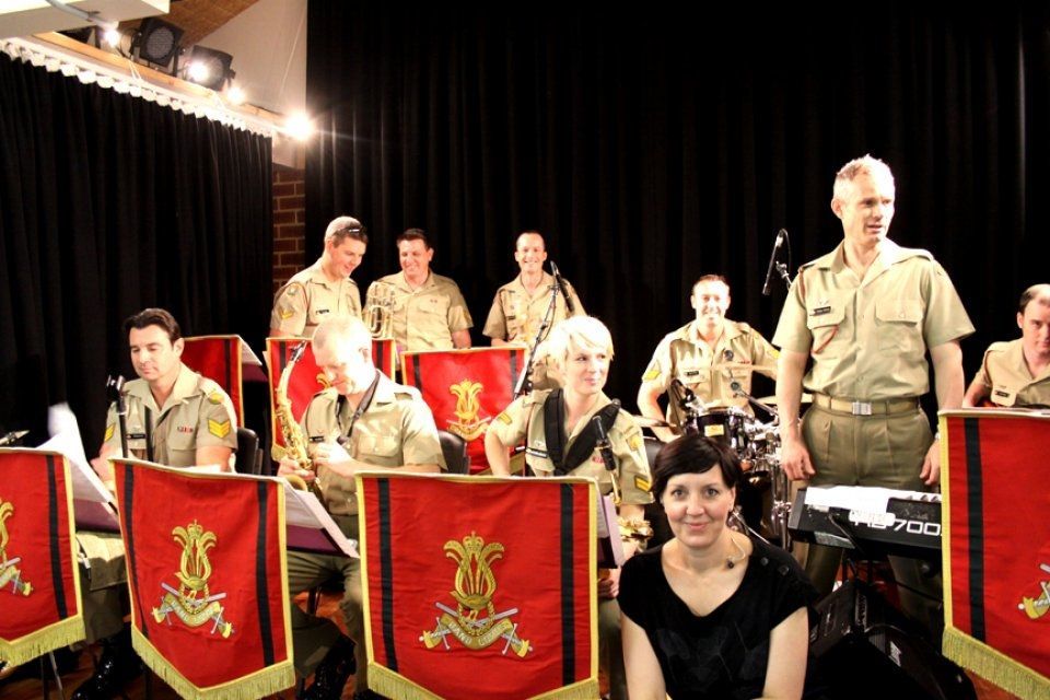 A woman is sitting in front of a military band