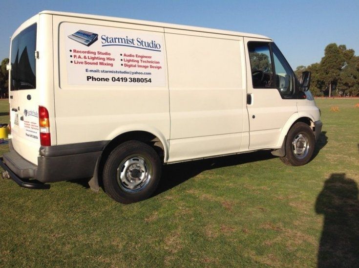 A white van that says starmist studio on the side