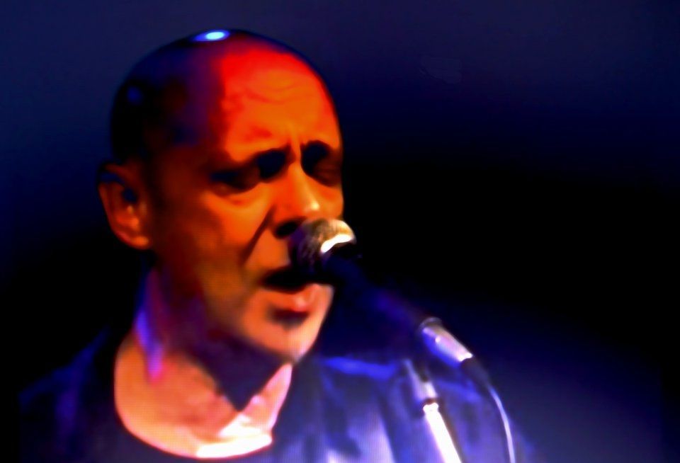 A man singing into a microphone in a dark room