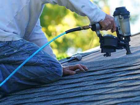 A roofing contractor inspecting a roof in Lake City, FL.