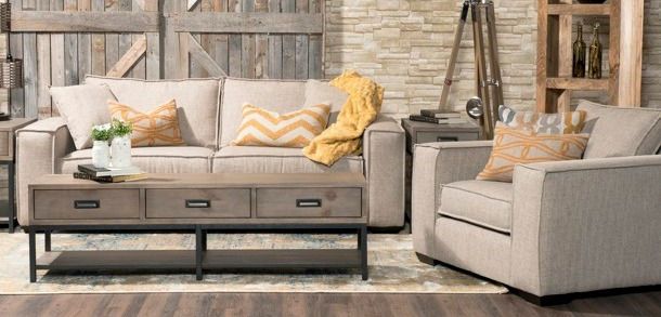 A living room with a couch , chair , coffee table and rug.