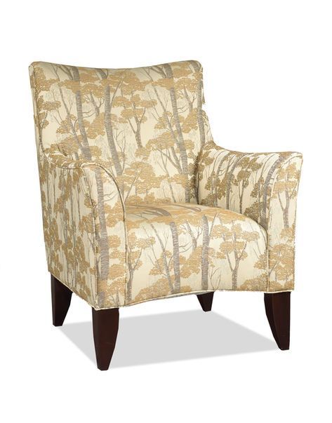 Upholstered armchair with a light coloured, tree-patterned fabric