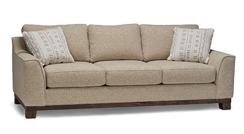 A beige couch with two pillows on it