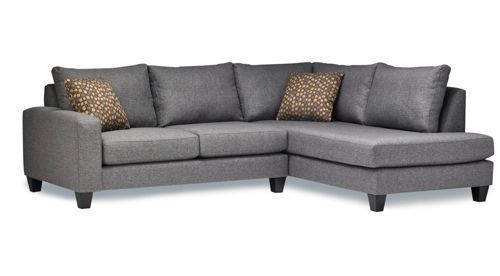 A dark grey sectional couch with pillows