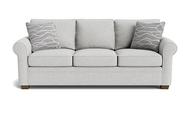 A white couch with two pillows on it