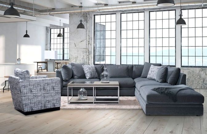 A living room with a large sectional grey couch and a chair.