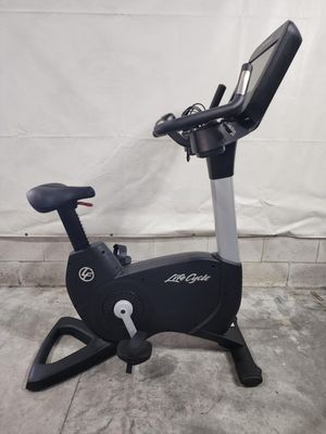 A black exercise bike is sitting on a concrete floor.