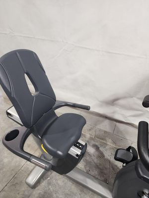 A recumbent exercise bike is sitting on a concrete floor.