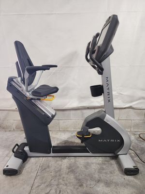 A matrix recumbent bike is sitting on a concrete floor.