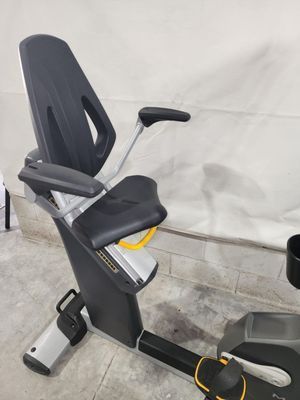 A recumbent exercise bike is sitting on a concrete floor.