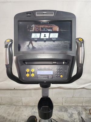 A matrix exercise bike with a large monitor on top of it.