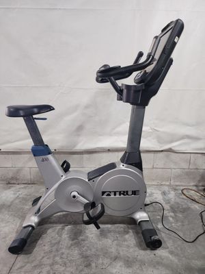 An exercise bike is sitting on the ground in a garage.