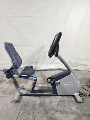 A recumbent exercise bike is sitting on a concrete floor.