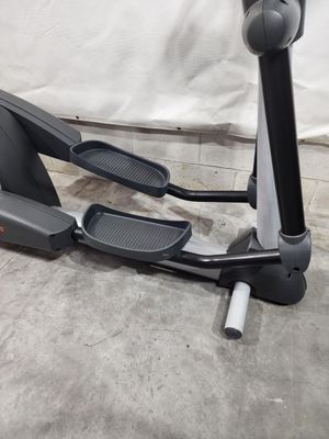 An elliptical machine is sitting on a concrete floor.