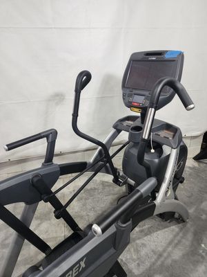 An elliptical machine is sitting on a concrete floor in a garage.