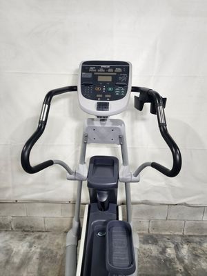 An elliptical machine is sitting in a garage next to a wall.