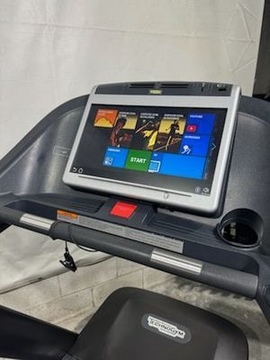 A treadmill with a tablet on top of it.
