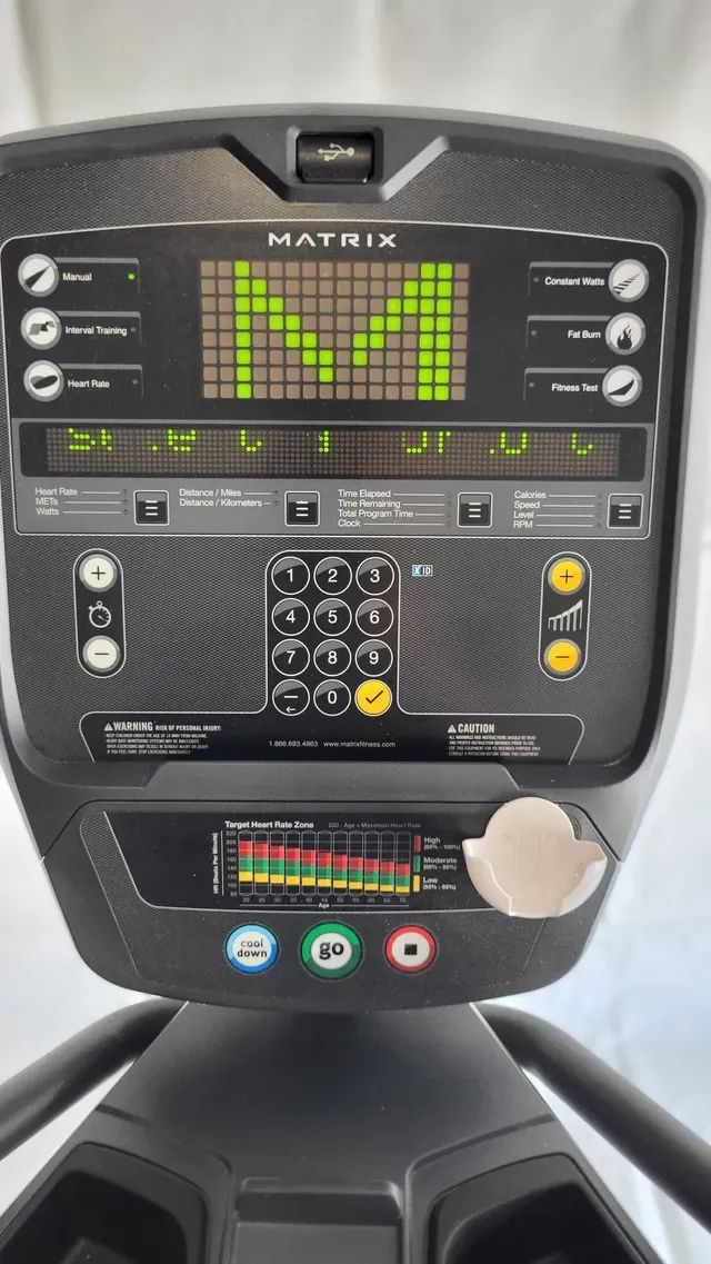 A close up of a matrix treadmill with a green screen