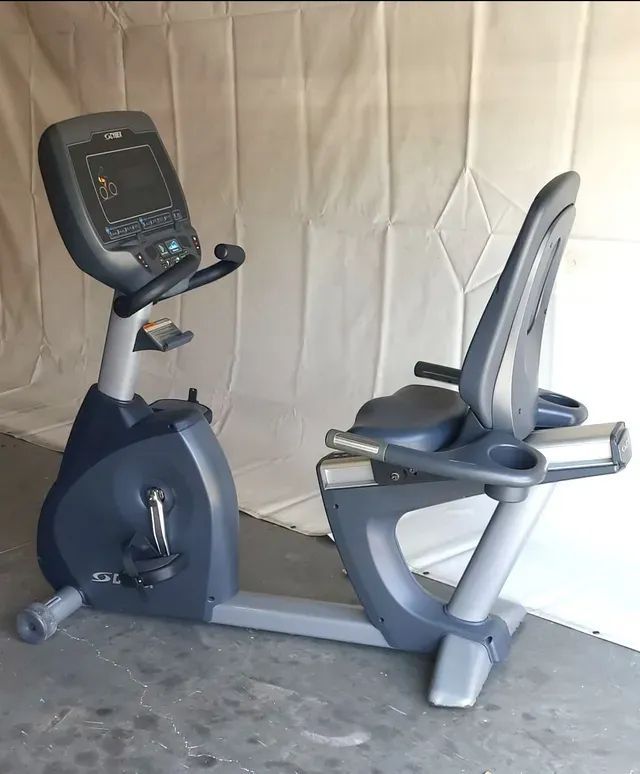 A recumbent exercise bike is sitting in front of a white curtain
