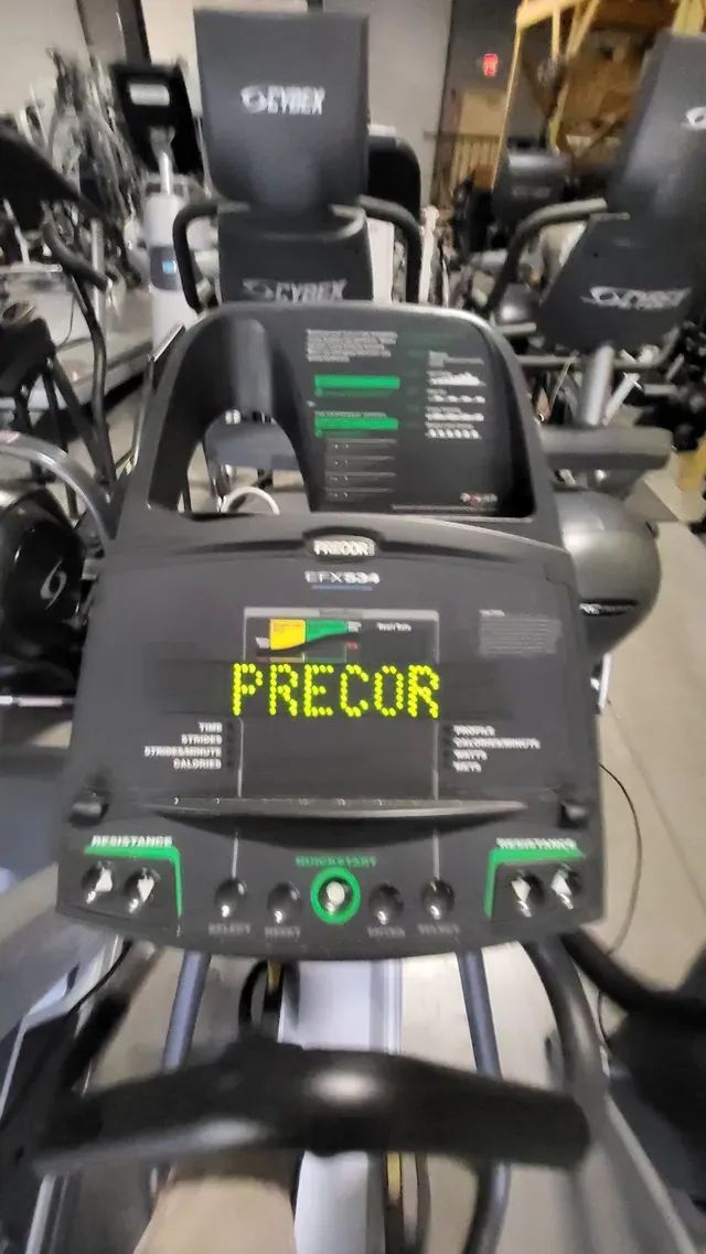 A treadmill with the word precor on it is in a gym.
